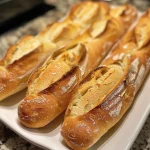 Close-up view of golden mini baguettes with a crusty exterior.