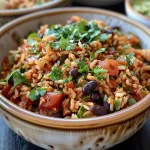 Close-up of a vibrant Mexican rice and bean bowl with ingredients layered.