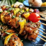 Close-up view of grilled tuna skewers with fennel and tomatoes.