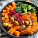 Close-up of a colorful Buddha bowl featuring chickpeas, carrots, and beetroot caviar.