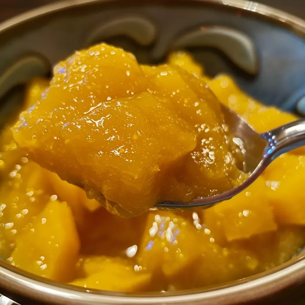 A detailed image showcasing a bowl of mango compote with citrus slices around it.
