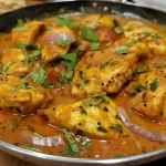 A close-up view of healthy Indian fish curry, showcasing vibrant colors and textures.