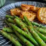 Close-up of fresh green haricots verts with garlic and herbs.