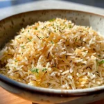 Close-up of cooked basmati rice in an air fryer basket.